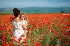 two girls in a field of red flowers