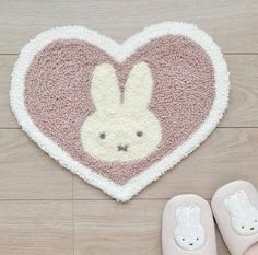 a pair of slippers sitting next to a heart shaped rug