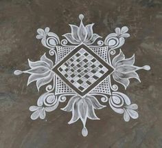 an artistic design on the ground in white and grey colors, with leaves around it