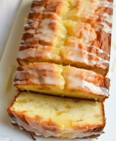 a loaf of lemon pound cake with icing on a white plate next to another loaf