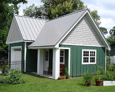 a small green and white house in the yard