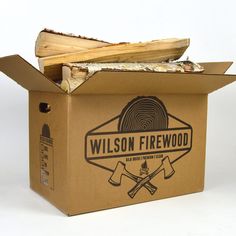 a cardboard box filled with firewood sitting on top of a white table