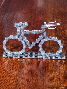 a bicycle made out of chains on a wooden table