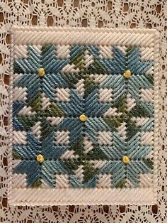 a white doily with blue and green designs on it