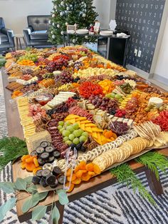 a long table covered with lots of different types of cheeses and fruit on it