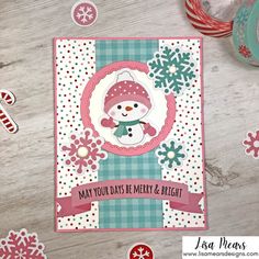 a christmas card with snowman and candy canes on the table next to it