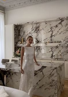 a woman standing in front of a marble counter top