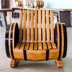 a wooden chair made out of wine barrels sitting on the floor in a room with tables and chairs