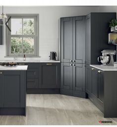 a kitchen with gray cabinets and white counter tops