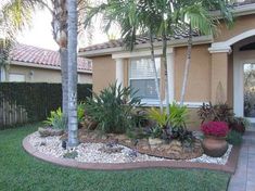 a house with palm trees in front of it and landscaping on the side of the house