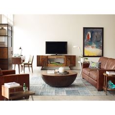 a living room filled with furniture and a flat screen tv on top of a wooden table