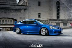 a blue car parked in front of a building