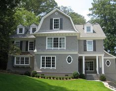 a large gray house with white trim and windows