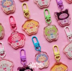 there are many different key chains on the pink surface with little pigs in them