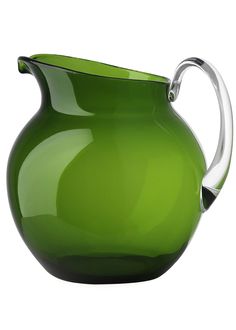 a green glass pitcher is shown on a white background with the handle still attached to it