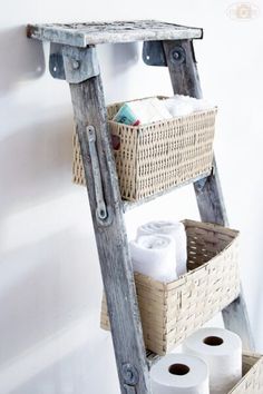 an old wooden ladder with baskets and toilet paper