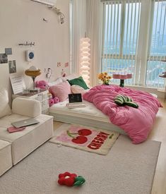 a white bedroom with pink and green decor on the bed, couches and rugs