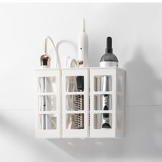 an assortment of beauty products are arranged on a white wall mounted organizer with glass compartments