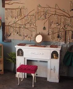 a living room filled with furniture and a tree wall hanging on it's side