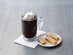 a cup of hot chocolate with marshmallows on a plate