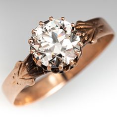 an antique diamond ring is shown on a white background with gold accents and leaves around the band