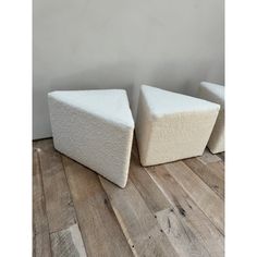 two white stools sitting on top of a wooden floor