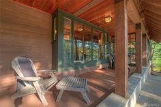 a wooden porch with two chairs on it