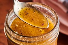 a spoon full of honey sits in a jar