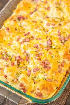 a casserole dish with ham and cheese in it sitting on a wooden table