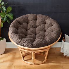 a chair with a cushion sitting on top of it next to a potted plant