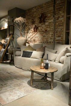 a living room with brick walls and furniture in the corner, including a couch and coffee table