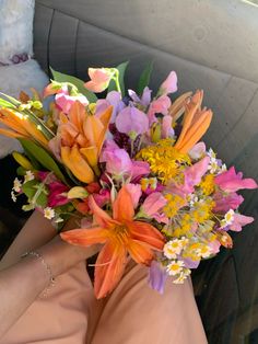 a bouquet of flowers sitting on top of a person's lap