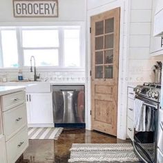 a kitchen with white cabinets and stainless steel appliances in the middle of the flooring