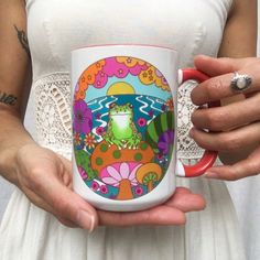 a woman holding a coffee mug with a frog on it