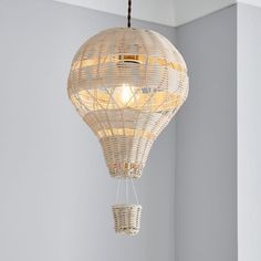 a white light fixture hanging from the ceiling in a room with gray walls and flooring