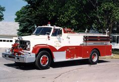 an old fire truck parked on the side of the road in front of a house