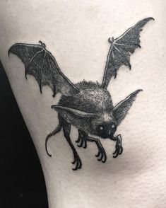 a black and white photo of a bat on the side of a woman's thigh