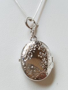 "This Sterling Silver Locket is hand assembled onto a 16\" 925 box chain. The locket has a beautiful floral pattern with 2 clear rhinestones above probably to indicate which way to wear. It is oval shaped hinged locket. On the inside hallmark: \"Toni 925 China\" . This item is new but hand assembled. Locket measures: 1\" L X 5/8\" W Box Chain measures: 16\" Material: Sterling Silver Locket and Chain Come in a gift box with tracking" Sterling Silver Locket, Oval Locket, Silver Locket, Silver Lockets, Enamel Jewelry, 925 Jewelry, Locket Necklace, 2 Photos, Gorgeous Earrings