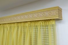 a yellow curtain hanging on the side of a window