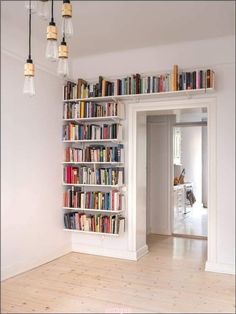 a bookshelf filled with lots of books in a room next to a doorway