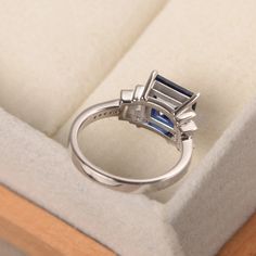 This ring features a 7mm square cut lab grown blue sapphire, baguette cut CZs as side stones,and sterling silver finished with rhodium. Customization is available. It is made by hand, and it will take about 7 days to finish the ring after your payment is completed. Any question, just let me know. :) My shop homepage: https://www.etsy.com/shop/LuoJewelry?ref=l2-shopheader-name Christmas Gift For Family, Memorial Ring, Blue Gemstone Rings, Engagement Ring For Women, Blue Sapphire Ring, London Blue Topaz Ring, Blue Square, Blue Band, Blue Sapphire Rings