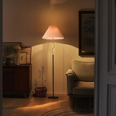 a living room with a lamp on the floor