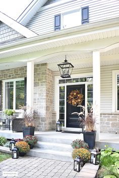 the front porch is decorated with flowers and plants