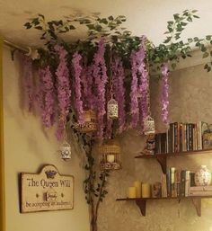 purple wister hanging from the ceiling in a room with bookshelves and shelves