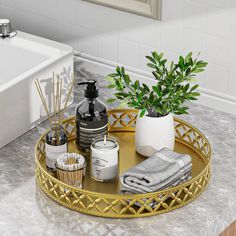 a gold tray with soap, toothbrushes and other bathroom items sitting on a marble countertop