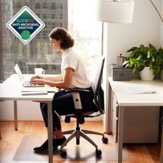 a woman sitting at a desk with a laptop computer in front of her and the logo for an anti - micronalia alternative