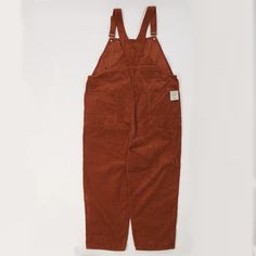 Cut from a thick-wale corduroy, in beautiful ‘brick’ colour option, this oversized dungaree draws inspiration from the great tradition of American workwear, but uses a modern edge. This luxuriously soft fabric is a far cry from what we might expect out traditional dungarees to be cut from, but this winning combination brings a classic design into the 21st Century. As is common with traditional ‘bib’ style overalls, this piece boasts steel tuck buttons on the hips for ease of dress, and two over Brick Colour, American Workwear, Style Overalls, Trouser Pocket, Far Cry, Bib Overalls, Trouser Style, Clothing Co, Dungarees