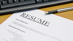 a resume sitting on top of a desk next to a keyboard