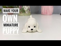 a white dog figurine sitting on top of a table next to vases