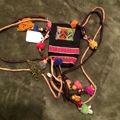 a small purse is laying on the ground with some beads and other things around it